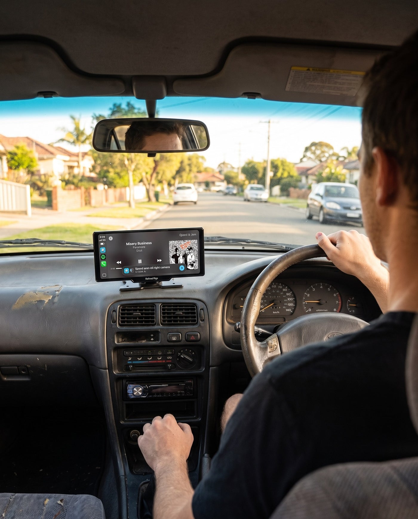 Driver on a test drive with the Evara Display on the dashboard playing music