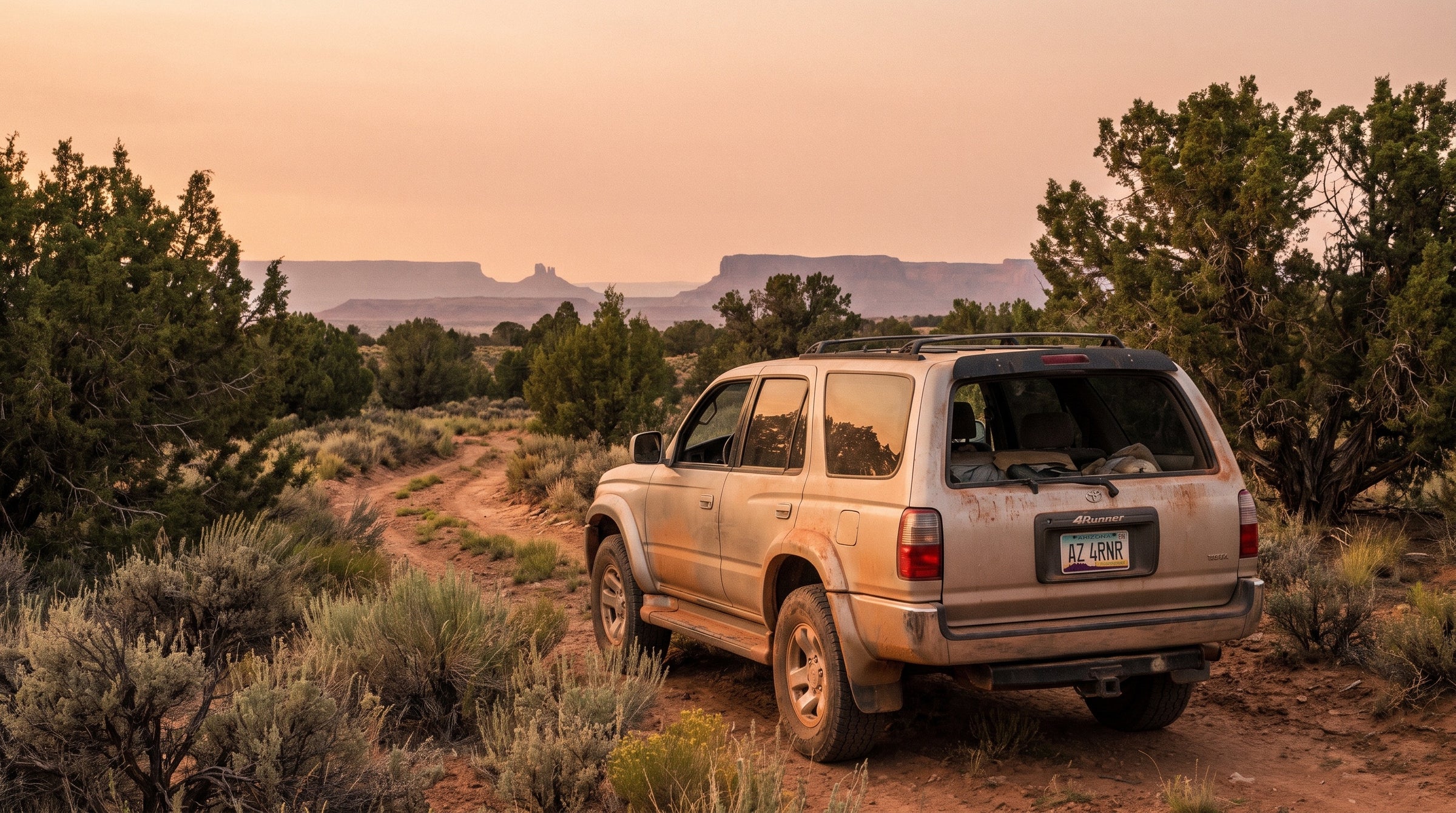 Dusty Toyota 4Runner on a desert forest road in Arizona at golden hour